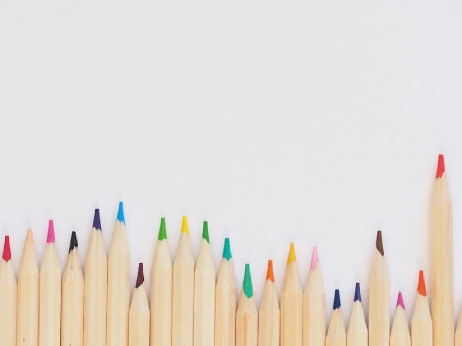 Sharpened colour pencils arranged on a white surface